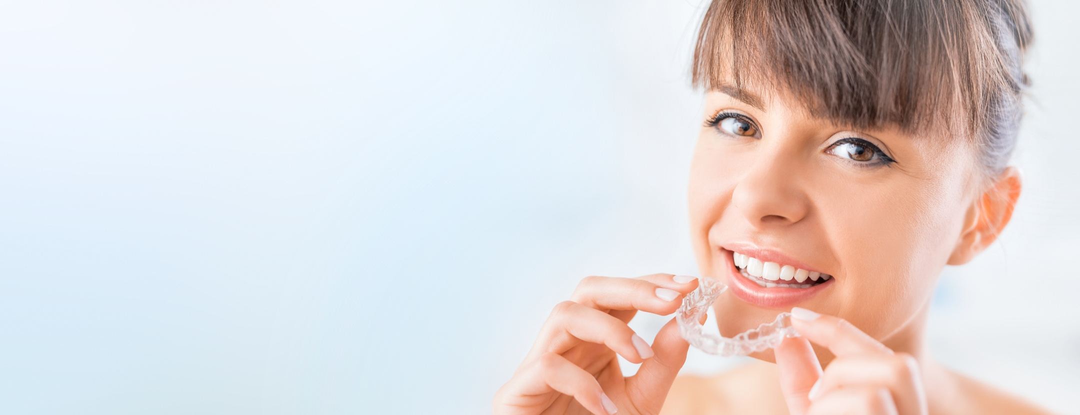 Woman putting in her clear Active Aligners aligner