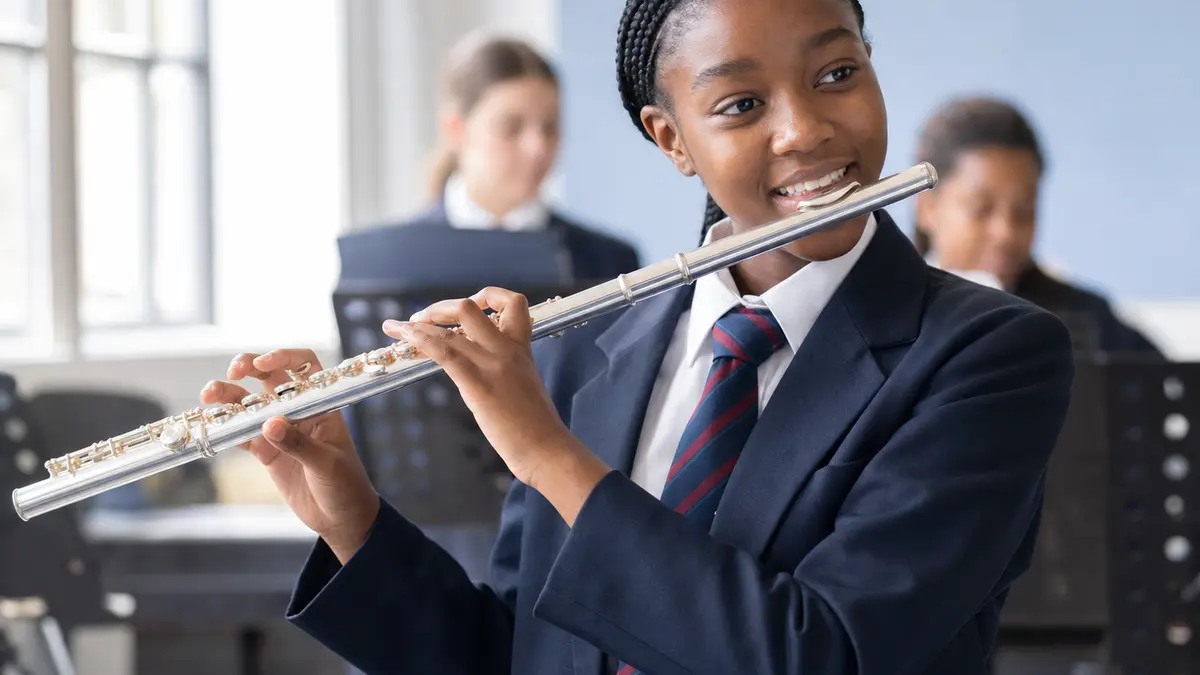 Teen student playing the flute at school